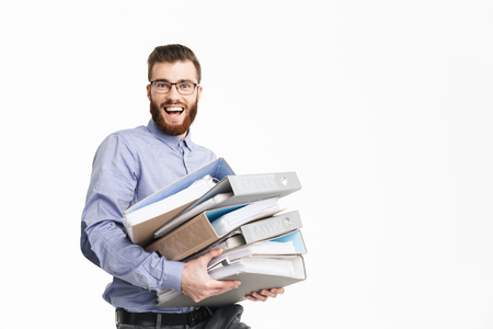 Happy bearded elegant man in eyeglasses holding folders and looking at the camera over grey backgroundの写真素材