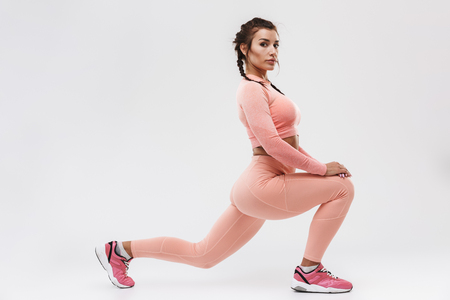 Picture of a beautiful young amazing strong sports fitness woman posing isolated over white wall background make exercises.の写真素材