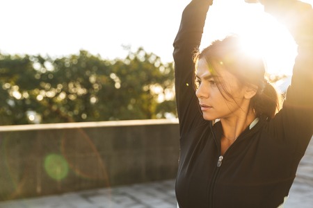 Attractive confident fitness woman wearing sportswear exercising on staircase outdoorsの写真素材