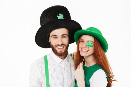 Happy young couple wearing costumes, celebrating St.Patrick 's Day isolated over white background, having fun together