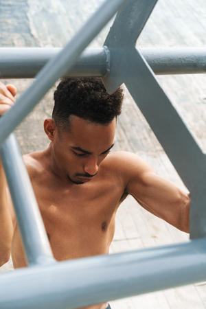 Photo of a strong handsome young african sports man outdoors at the beach sea walking make exercises.の写真素材