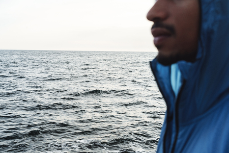Cropped photo of a strong handsome young african sports man outdoors at the beach sea.の写真素材