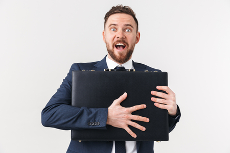 Image of young excited businessman posing isolated over white wall background holding bag case.の写真素材