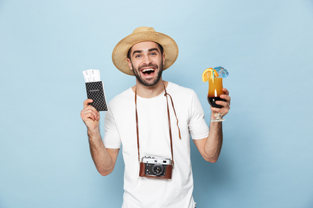 Cheerful excited man wearing blank t-shirt standing isolated over blueの写真素材