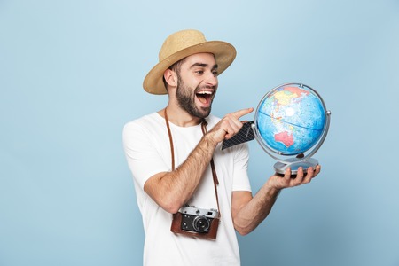 Cheerful excited man wearing blank t-shirt standing isolated over blueの写真素材