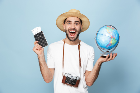 Cheerful excited man wearing blank t-shirt standing isolated over blueの写真素材