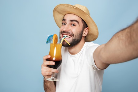 Cheerful excited man wearing blank t-shirt standing isolated over blueの写真素材