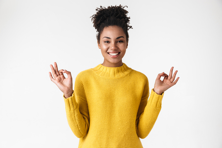 Image of a beautiful young african happy emotional woman posing isolated over white wall background make okay gesture.の写真素材