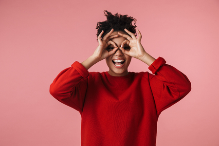 Image of a beautiful young happy african woman posing isolated over pink wall background make okay gesture.の写真素材
