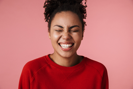 Image of a beautiful amazing laughing happy young african woman posing isolated over pink wall background.の写真素材