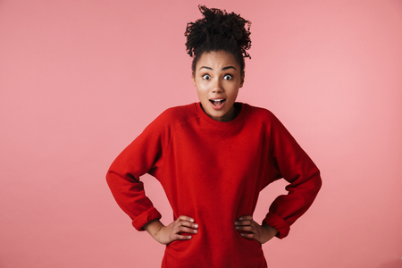 Image of a beautiful amazing young happy excited african woman posing isolated over pink wall background.の写真素材
