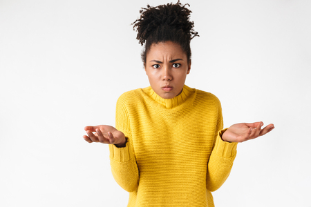 Photo of a beautiful young african confused woman posing isolated over white wall background.の写真素材