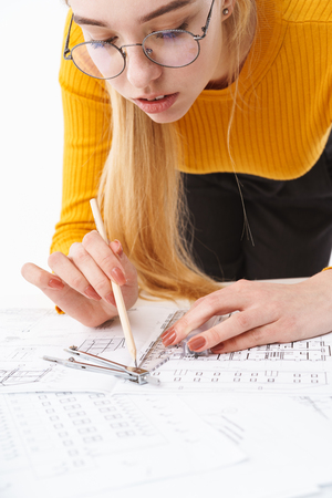 Cropped image of a beautiful young blonde woman architect standing isolated over white backgroundの写真素材