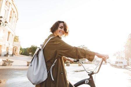 Image of a cute young amazing woman walking outdoors in park with bicycle beautiful spring day.の写真素材