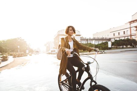 Image of a cute young amazing woman walking outdoors in park with bicycle beautiful spring day.の写真素材