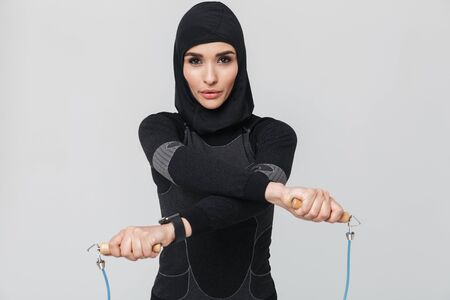 Image of young woman fitness muslim posing isolated over white wall background make exercises with...
