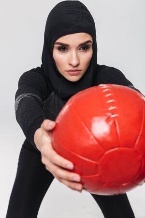 Image of young woman fitness muslim make exercises with ball isolated over white wall background.の写真素材