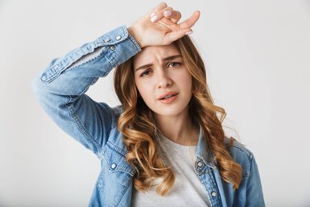 Image of a beautiful tired young pretty woman posing isolated over white wall background.