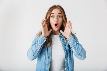 Attractive young girl standing isolated over white background, shouting loudの写真素材
