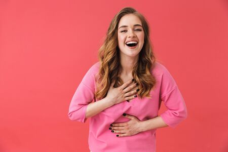 Beautiful cheerful young girl wearing casual clothes standing isolated over pink backgound, laughingの写真素材