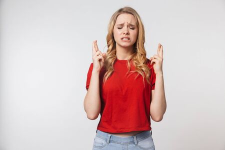 Image of nervous young pretty beautiful woman posing isolated over white wall background showing hopeful please gesture.の写真素材