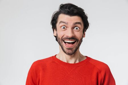 Image of a handsome young happy man posing isolated over white wall background.