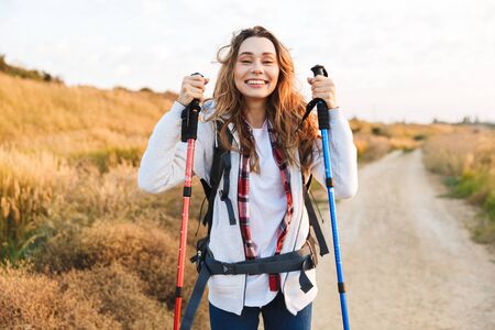 Happy young girlcarrying backpack, hikingの写真素材