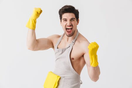 Handsome shirtless brunette houseman wearing apron standing isolated over white background, flexing musclesの写真素材
