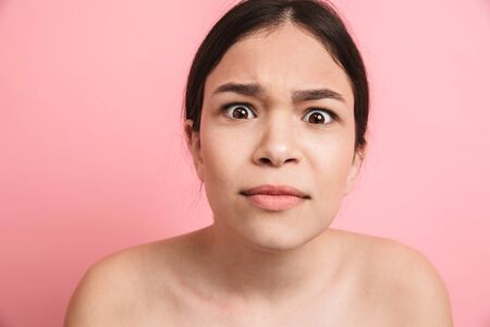 Photo closeup of european shirtless girl with dark hair grimacing and looking at cameraの写真素材