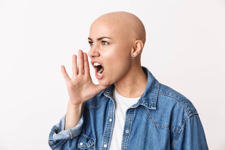 Image of a beautiful screaming angry bald woman posing isolated over white wall background.の写真素材