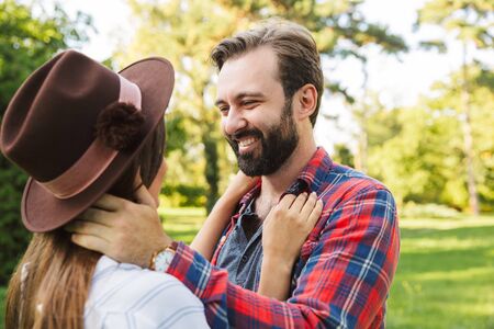 Close up of a beautiful lovely couple in love spending time at the park, embracing, looking at each otherの写真素材