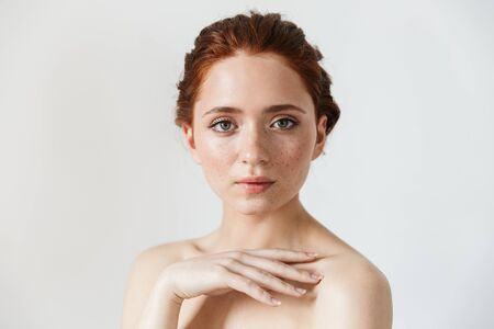 Portrait of a pretty young redhead woman posing isolated over white wall background.の写真素材