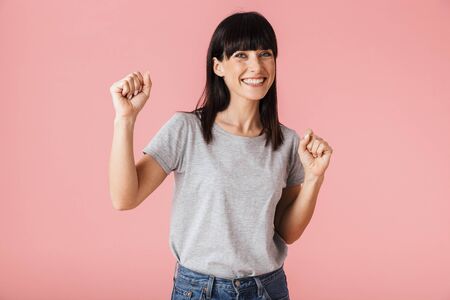 Image of a beautiful amazing woman posing isolated over light pink background wall.の写真素材