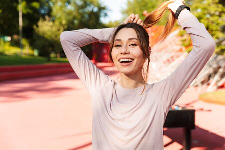 Image of a beautiful young fitness sports woman posing outdoors in park.の写真素材