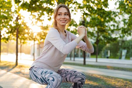 Attractive young fitness woman wearing sports clothing exercising outdoors