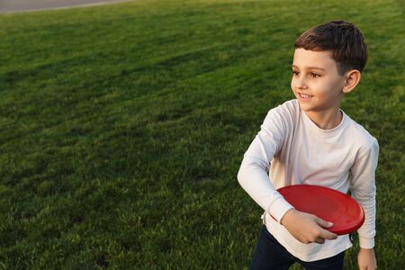 Image of a happy little boy outoors in park beautiful green grass play game with father.