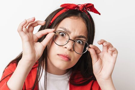 Close up of a cute funny teenage girl wearing casual outfit standing isolated over white background,...