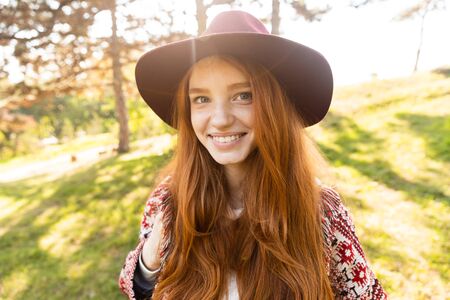 Image of optimistic cheerful smiling happy young student redhead girl in autumn park walking.の写真素材