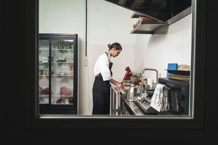 Image of a handsome young cook chef at the kitchen cooking indoors.の写真素材