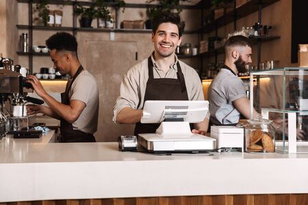 Image of three happy coffee men colleagues in cafe bar working indoors.の写真素材