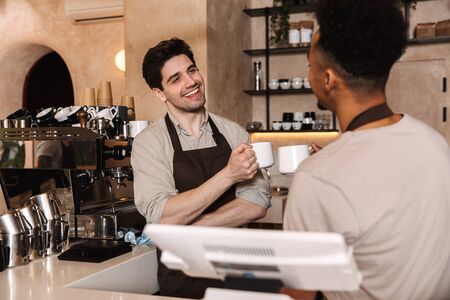 Image of two happy coffee men colleagues in cafe bar working indoors.の写真素材