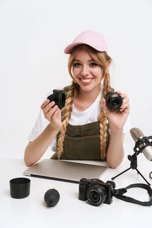 Image of caucasian girl recording blog broadcast with microphone about new professional camera and...