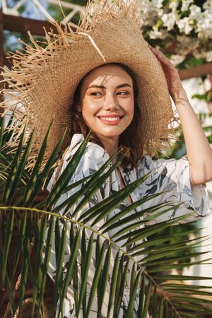 Photo of a cheery optimistic happy young beautiful woman at the beach walking in a beautiful sunny...