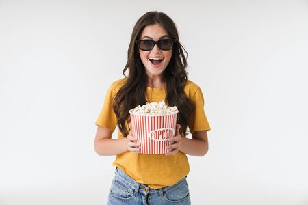 Image of happy positive young woman isolated over white wall background in 3d glasses eat popcorn watch film.の写真素材