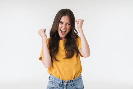 Image of happy brunette woman wearing casual t-shirt screaming and rejoicing isolated over white...