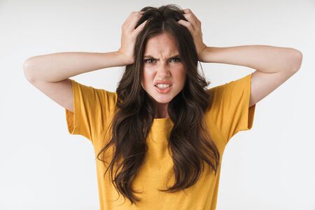 Image of confused resentful woman wearing casual t-shirt grabbing head in irritation isolated over...