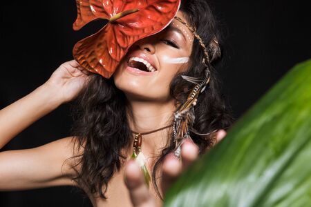 Beauty portrait of an attractive laughing young brunette woman wearing tribal accessories posing...