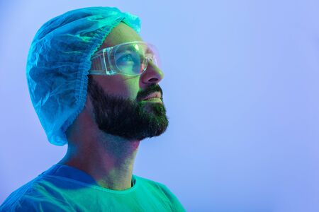 Close up portrait of a confident man scientist wearing unifrom and glasses standing isolated over...