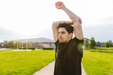 Image of sporty man in sportswear working out and running at green park outdoors in morningの写真素材