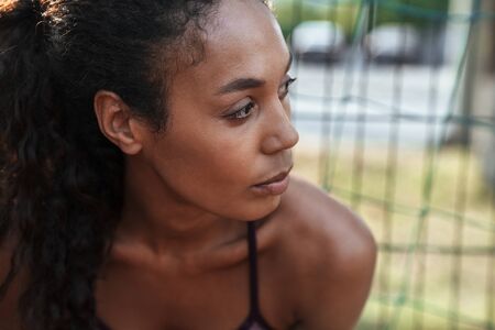 Close up of a confident young fit african sportswoman standing at the sportsground